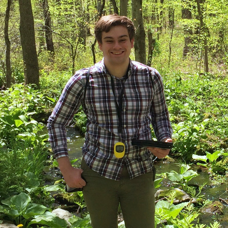 Photo of Eric Wuesthoff in a forest with a GPS receiver and tablet.